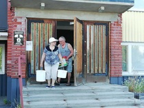 Helli ja Taisto kantamassa lettutaikinoita ja kahvitustarvikkeita kyytiin.