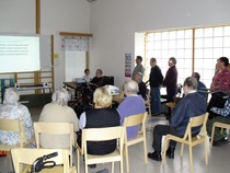 Kuoro ja hanuristi ilahduttamassa ikäihmisiä Suvituulessa.